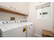 Laundry room features newer washer and dryer appliances, white cabinets, and natural light at 21901 N Sonora Ln, Sun City West, AZ 85375