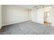 Comfortable bedroom with soft carpet, white walls, and a sliding barn door leading to the ensuite bathroom at 22129 W Laura St, Wittmann, AZ 85361