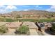 Stunning aerial view of desert homes, with a lush golf course nestled amidst rolling hills and blue skies at 2214 W Muirfield Dr, Anthem, AZ 85086