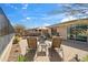 Relaxing backyard features mature desert landscaping, lounge chairs, and a dining table under the sunny sky at 2214 W Muirfield Dr, Anthem, AZ 85086