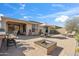 Inviting backyard with desert landscaping, a built-in fire pit, and ample seating under blue skies at 2214 W Muirfield Dr, Anthem, AZ 85086