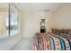 Bright bedroom with large window, patterned bedspread, and ensuite bathroom access at 2214 W Muirfield Dr, Anthem, AZ 85086