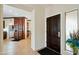 Home foyer featuring a dark wood front door and trim, tile floors, and adjacent access to the kitchen at 2214 W Muirfield Dr, Anthem, AZ 85086