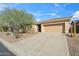 Attractive single-story home with a well-manicured front yard, complemented by desert landscaping and a spacious driveway at 2214 W Muirfield Dr, Anthem, AZ 85086