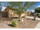 Charming home surrounded by desert landscaping, featuring a well-maintained yard and mature trees for added privacy at 2214 W Muirfield Dr, Anthem, AZ 85086