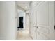 Well-lit hallway featuring tile flooring, white trim, and contrasting black door at 2214 W Muirfield Dr, Anthem, AZ 85086