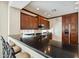Gourmet kitchen with a bar-top featuring dark granite countertops and wood cabinets and stainless steel appliances at 2214 W Muirfield Dr, Anthem, AZ 85086