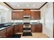 Charming kitchen with dark wood cabinets, black countertops, and stainless steel appliances at 2214 W Muirfield Dr, Anthem, AZ 85086