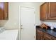 Cozy laundry area with dark wood cabinetry and a white washer next to a door at 2214 W Muirfield Dr, Anthem, AZ 85086