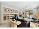 Open-concept living room with built-in shelves, a black sofa, and sliding doors leading to an outdoor patio at 2214 W Muirfield Dr, Anthem, AZ 85086