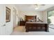 Spacious bedroom with decorative headboard, bedside tables, and ensuite bathroom access at 2214 W Muirfield Dr, Anthem, AZ 85086