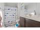 Bright bathroom features modern vanity and a tub with a shark themed shower curtain at 2423 N Beverly Pl, Buckeye, AZ 85396
