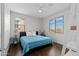 Bright bedroom featuring hardwood floors, a ceiling fan, and picturesque outdoor views from two windows at 2423 N Beverly Pl, Buckeye, AZ 85396