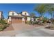 Inviting two-story home featuring a three-car garage and desert landscaping under a clear blue sky at 2423 N Beverly Pl, Buckeye, AZ 85396