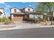 Inviting two-story home featuring a three-car garage and desert landscaping on a sunny day at 2423 N Beverly Pl, Buckeye, AZ 85396