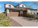 Beautiful two-story home featuring a three-car garage and desert landscaping at 2423 N Beverly Pl, Buckeye, AZ 85396