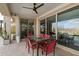 Covered patio with tile flooring, ceiling fan, and outdoor dining set next to large sliding glass doors at 2423 N Beverly Pl, Buckeye, AZ 85396