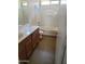 Bathroom featuring wood cabinets, a white shower-tub combo, and coordinated fixtures for a clean, functional design at 24930 W Dove Mesa Dr, Buckeye, AZ 85326