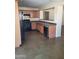 Cozy kitchen with wood cabinets, black appliances, and a breakfast bar at 24930 W Dove Mesa Dr, Buckeye, AZ 85326