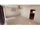 Open-concept living room with tile flooring, ceiling fan, shelving, and a view into the kitchen area at 2502 W Jefferson St, Phoenix, AZ 85009
