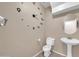 Charming half-bath featuring a pedestal sink, toilet, and a unique wall clock for a modern touch at 2987 E Powell Way, Gilbert, AZ 85298