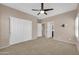 Bedroom with plush carpet, ceiling fan, and double-door closet at 2987 E Powell Way, Gilbert, AZ 85298