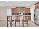 Kitchen with dark cabinetry, stainless appliances, granite countertops, and three-seat breakfast bar at 2987 E Powell Way, Gilbert, AZ 85298