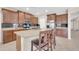 Kitchen island with granite countertops, stainless appliances, and dark wood cabinets with seating for three at 2987 E Powell Way, Gilbert, AZ 85298