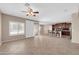 Spacious living room with tiled floor, ceiling fan, and large window for natural light flows into the kitchen at 2987 E Powell Way, Gilbert, AZ 85298