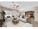 Cozy living room with white sofas, wood accents, a ceiling fan, and access to the kitchen and dining area at 2987 E Powell Way, Gilbert, AZ 85298