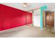 A red-walled bedroom featuring a mirrored closet, built in storage, and neutral carpeting at 3031 N Civic Center Plz # 205, Scottsdale, AZ 85251