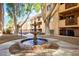 Serene courtyard with a tiered fountain as the focal point and mature trees at 3031 N Civic Center Plz # 205, Scottsdale, AZ 85251