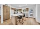 Inviting kitchen features wood cabinetry, stainless appliances, island seating, and a view to the backyard through the door at 3037 E Pueblo Ave, Mesa, AZ 85204