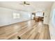 Bright living room open to kitchen featuring wood-look flooring, ceiling fan, and large windows at 318 S Crismon Rd # 83, Mesa, AZ 85208