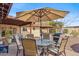 Outdoor dining area under a patio umbrella with a barbecue grill, perfect for entertaining in the spacious backyard at 3221 N 41St Pl, Phoenix, AZ 85018