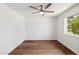 Empty bedroom with wood-look floors, ceiling fan, white walls, and a bright window with an outdoor view at 3221 N 41St Pl, Phoenix, AZ 85018
