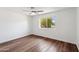 Empty bedroom with wood-look floors, ceiling fan, white walls, and a bright window with an outdoor view at 3221 N 41St Pl, Phoenix, AZ 85018