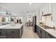 Open-concept kitchen boasts gray cabinetry, an island with countertop, and a view into the living and dining areas at 3221 N 41St Pl, Phoenix, AZ 85018