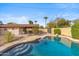 Lush backyard featuring a sparkling pool with a stone surround and a covered patio area, perfect for relaxation at 3221 N 41St Pl, Phoenix, AZ 85018