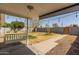Covered backyard patio with a white porch swing, patio lights and walkway to a fenced yard at 3607 N 21St Ave, Phoenix, AZ 85015