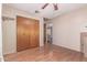 Well-lit bedroom showcasing wood floors, closet with paneled doors, and beige walls with view into the hallway at 3607 N 21St Ave, Phoenix, AZ 85015