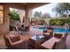 Gorgeous pool area with a covered patio, stone waterfalls, lush landscaping, and stylish patio furniture at 3634 E Sands Dr, Phoenix, AZ 85050