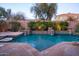 Luxurious pool area with tiered stone waterfalls, lush greenery, and inviting landscaping at 3634 E Sands Dr, Phoenix, AZ 85050