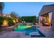Outdoor pool area with stone accents, water features, lounge chairs, and a covered patio at 3634 E Sands Dr, Phoenix, AZ 85050