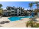 A pristine pool area is framed by apartment buildings and swaying palm trees, complete with tables and seating at 3848 N 3Rd Ave # 1047, Phoenix, AZ 85013