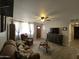 Comfortable living room with a ceiling fan, wood-look tile flooring, and a cozy seating area at 3932 W Lawrence Ln, Phoenix, AZ 85051