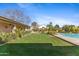 Expansive backyard featuring a well-manicured lawn, desert landscaping, and a sparkling pool at 4066 E Grandview St, Mesa, AZ 85205