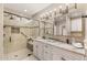 Bright bathroom featuring dual sinks, granite countertops and a walk-in shower with decorative tile accents at 4066 E Grandview St, Mesa, AZ 85205