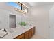 Bathroom with a dual sink vanity, decorative lighting, and a large mirror at 4066 E Grandview St, Mesa, AZ 85205