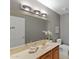 Bathroom featuring a single sink vanity with storage, a large mirror, decorative lighting, and a toilet at 4066 E Grandview St, Mesa, AZ 85205